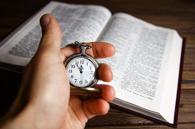 Une montre de poche entre les mains d'un homme