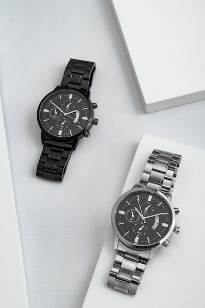 Photo montres de luxe en noir et argent sur table blanche accessoires pour homme d'affaires