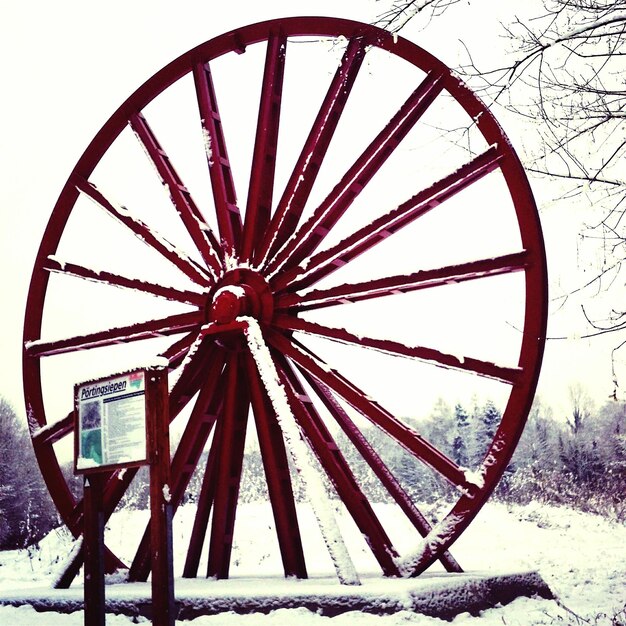 Photo monument à la roue en bois dans la neige