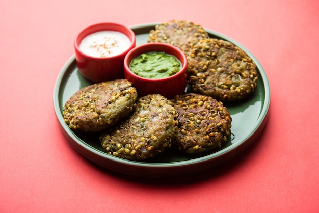 Moong dal tikki ou galettes germées est une collation saine d'Inde servie avec du chutney vert et du caillé