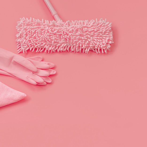 MOP, gants de chiffon et de caoutchouc-rose sur fond rose pour le nettoyage de printemps