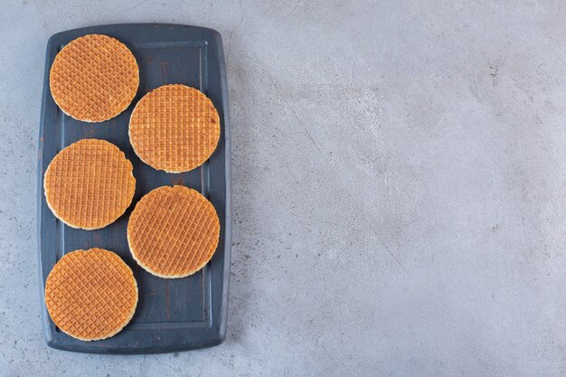 Morceau de collations de stroopwaffle maison brune dans une planche de bois.