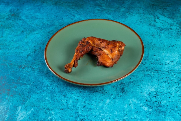 Morceau de cuisse de poulet barbecue servi dans un plat isolé sur fond vue latérale