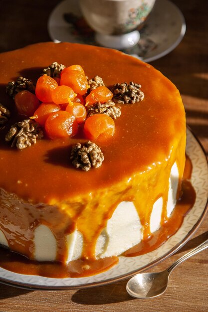 Morceau de délicieux gâteau aux carottes avec fudge au caramel aux noix et kumquats confits fond sombre gros plan