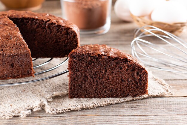 Morceau de délicieux gâteau éponge au chocolat frais fait maison sur table en bois