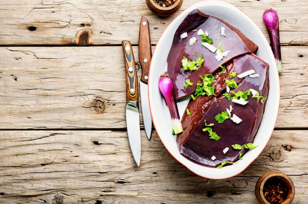 Morceau de foie de boeuf cru sur la table de la cuisine