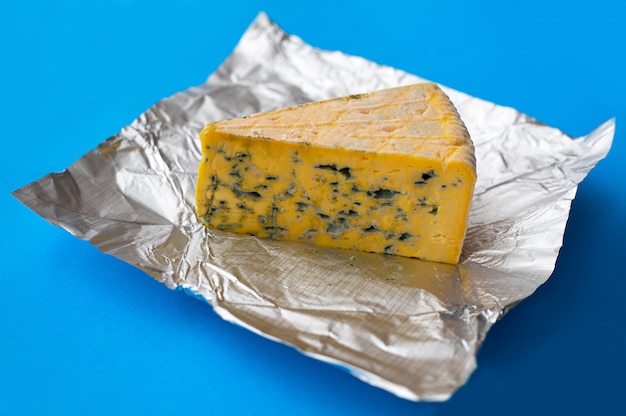 Morceau de fromage moisi sur une table bleue