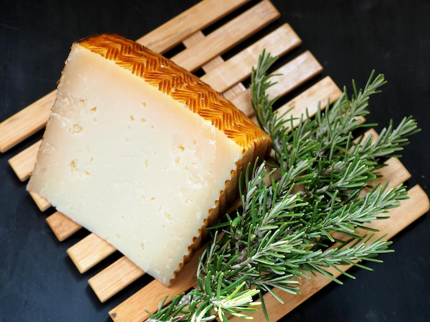 Morceau de fromage romarin frais sur une planche de bois Concept de cuisine méditerranéenne