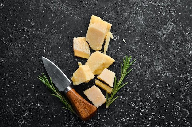 Morceau de fromage solide sur fond de pierre noire Parmesan Vue de dessus Espace libre pour votre texte