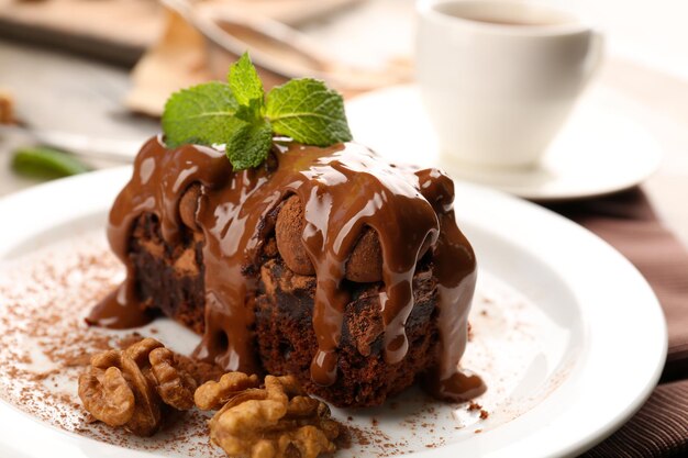 Un morceau de gâteau au chocolat avec noix et menthe sur le gros plan de table
