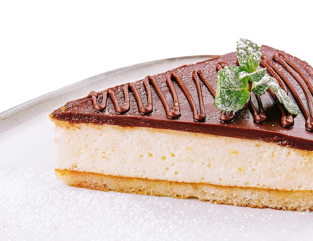 Morceau de gâteau au fromage au chocolat décoré de menthe sur assiette