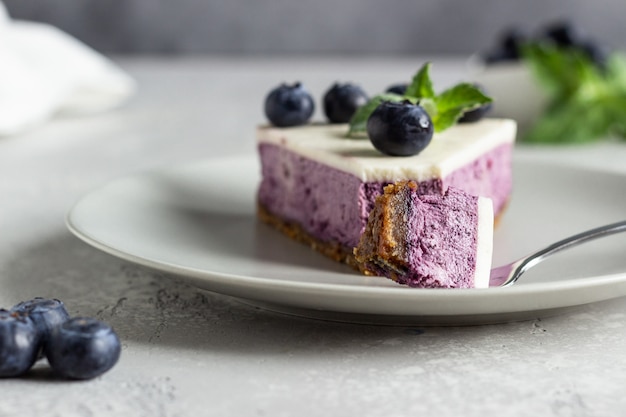 Morceau de gâteau au fromage aux myrtilles, myrtilles fraîches et menthe