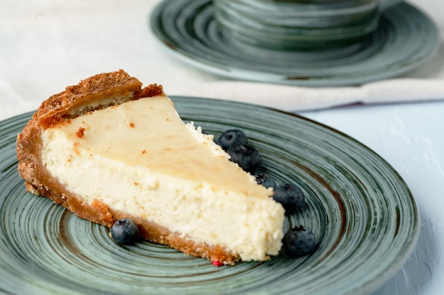 Morceau de gâteau au fromage classique sur plaque verte