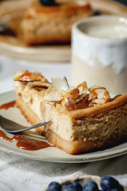 Morceau de gâteau au fromage avec noix de coco et caramel