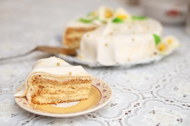 Morceau de gâteau au mastic blanc décoré de fleurs, gros plan