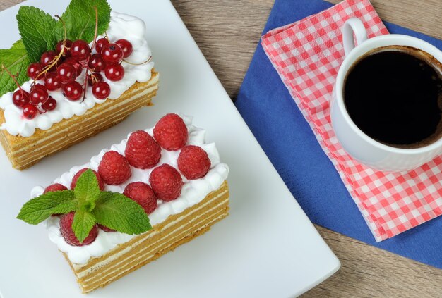 Morceau de gâteau au miel avec crème fouettée et framboises