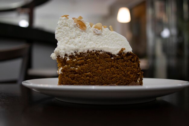 Un morceau de gâteau aux carottes recouvert de crème Mise au point sélective En arrière-plan la cafétéria