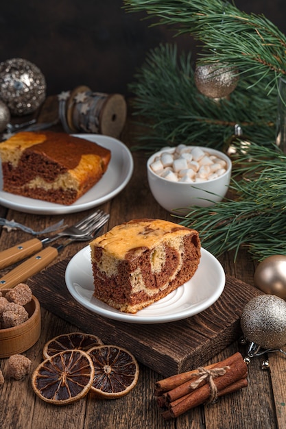 Un morceau de gâteau sur un fond festif avec des branches de pin. Le concept de Noël et du nouvel an. Vue latérale, verticale.