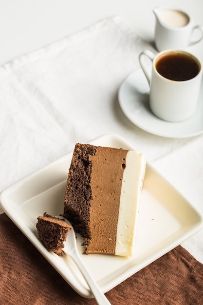 Un morceau de gâteau mousse "trois chocolats" saupoudré de chocolat râpé et de bonbons décorés