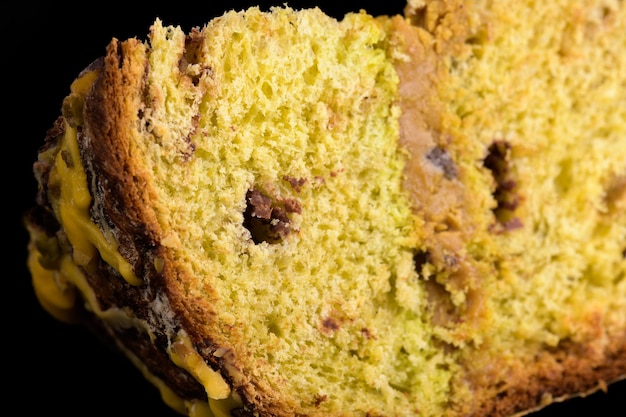 Morceau de gâteau de Noël traditionnel italien panettone sur fond noir gros plan