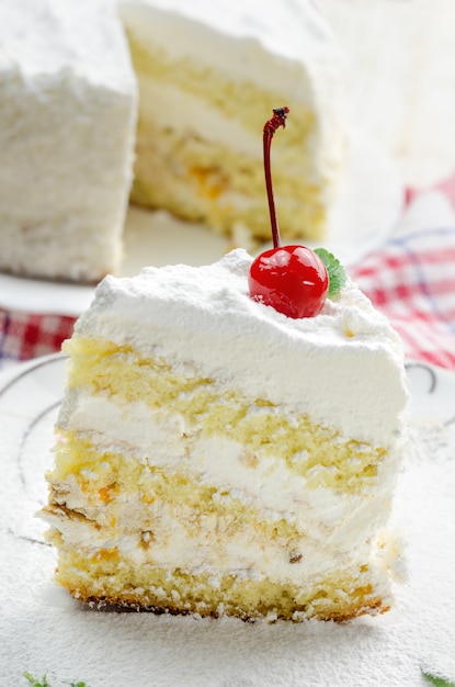 Morceau de gâteau à la noix de coco sur une plaque blanche.