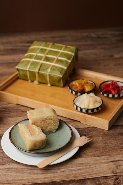 Morceau de gâteau de riz gluant cuit pour la célébration du tet à côté d'un plateau avec des légumes marinés