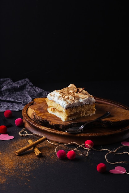 Morceau de gâteau trois lait préparé à la maison L'image est faite sur un fond sombre et des planches rustiques