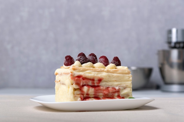 Morceau de gâteau à la vanille avec crème, sirop de fruits et baies. Fermer.