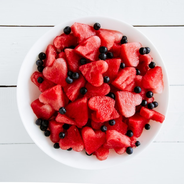 Morceau de melon d'eau et coeurs sur fond blanc