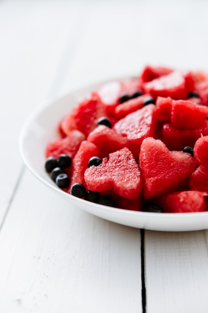 Morceau de melon d'eau et coeurs sur fond blanc