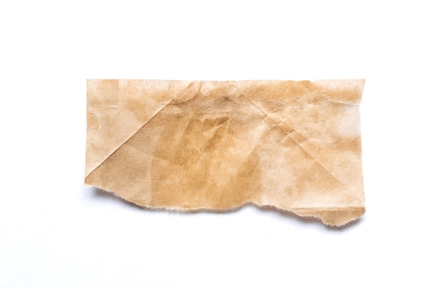 Morceau de papier brun déchiré sur fond blanc