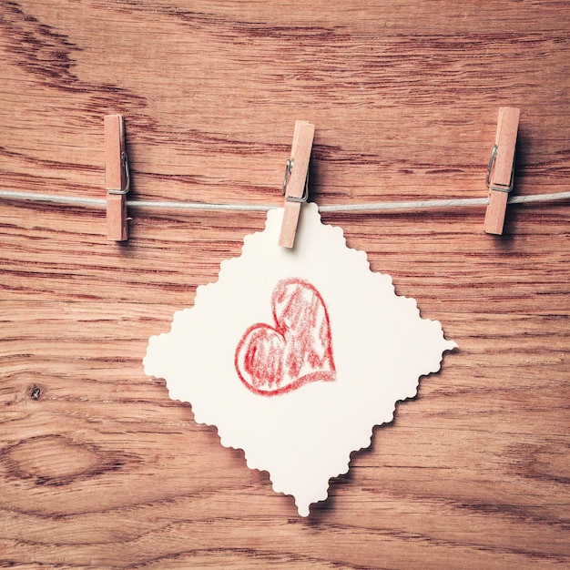 Morceau de papier avec un coeur dessiné sur une pince à linge photo with copy space