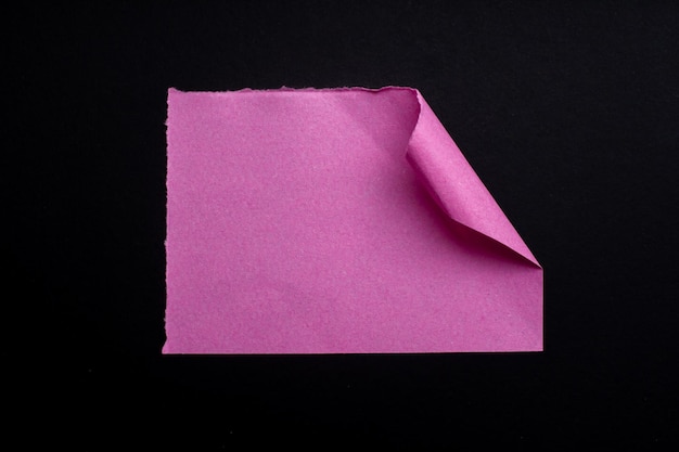 Un morceau de papier plié en origami rose avec le coin montrant le coin du coin.