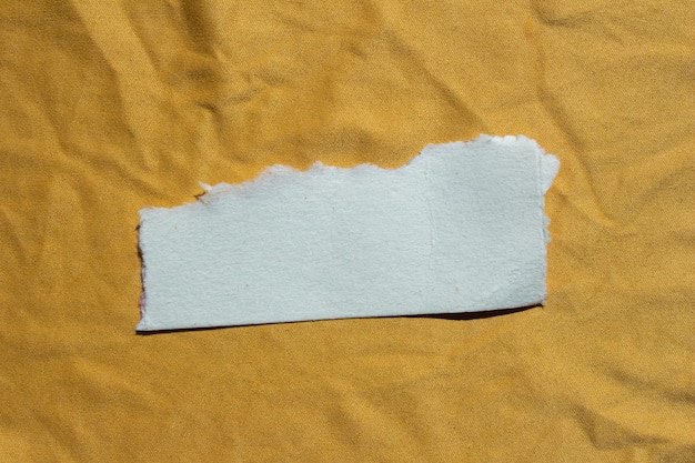 Un morceau de papier qui a été arraché par une feuille jaune.