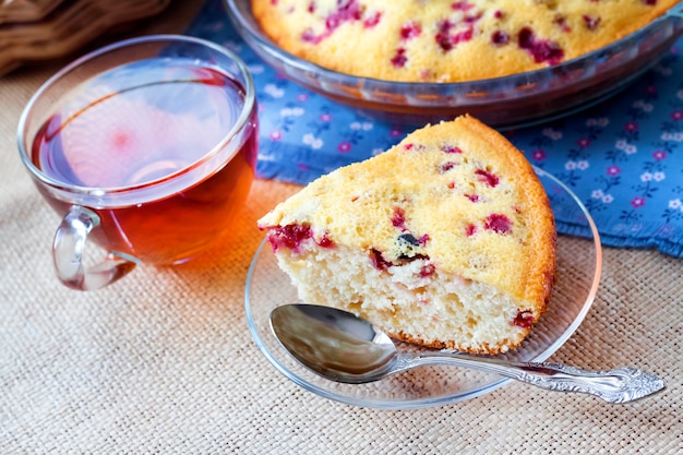 Morceau de tarte aux airelles sur plaque de verre et tasse de thé