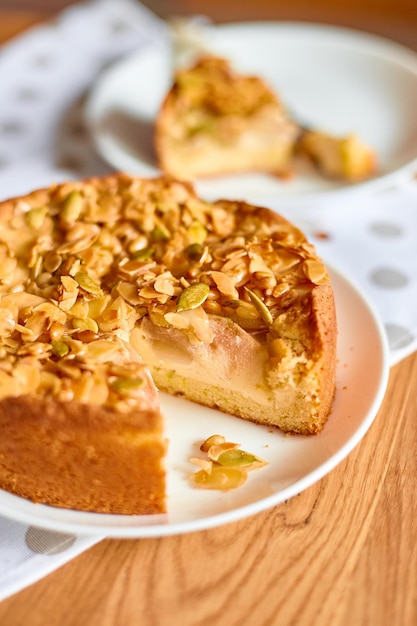 Morceau de tarte aux pommes ou aux poires avec des noix de caramel sur la vue de dessus de l'espace de copie de table en bois