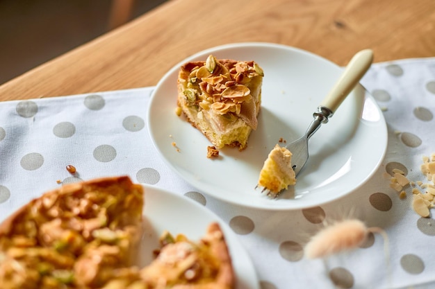 Morceau de tarte aux pommes ou aux poires avec des noix de caramel sur la vue de dessus de l'espace de copie de table en bois