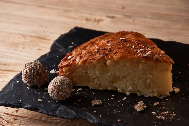 Photo un morceau de tarte aux pommes avec du chocolat râpé près de bonbons à la truffe au chocolat.