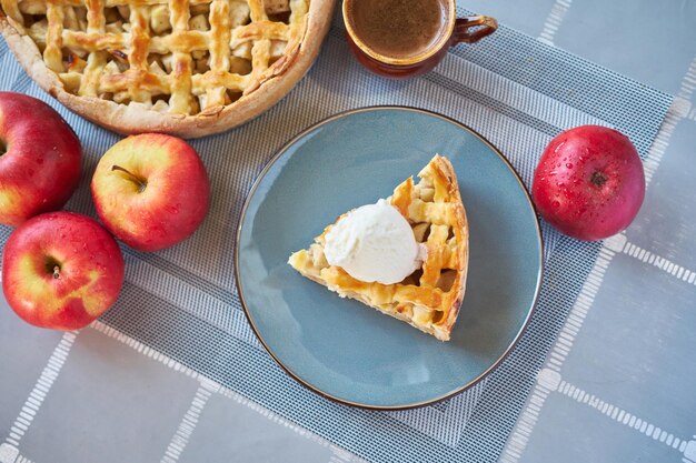 Morceau de tarte aux pommes traditionnelle maison fraîche avec de la glace sur une cuisine domestique