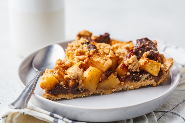 Morceau de tarte aux pommes végétalien à la cannelle, fond blanc. Concept alimentaire végétalien.