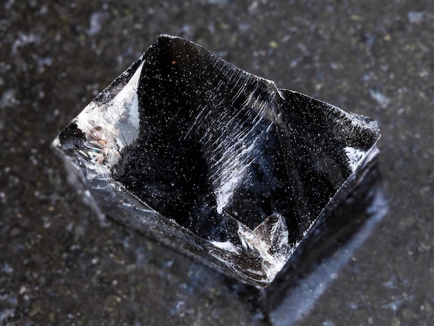 Morceau de verre volcanique obsidienne rugueux sur dark