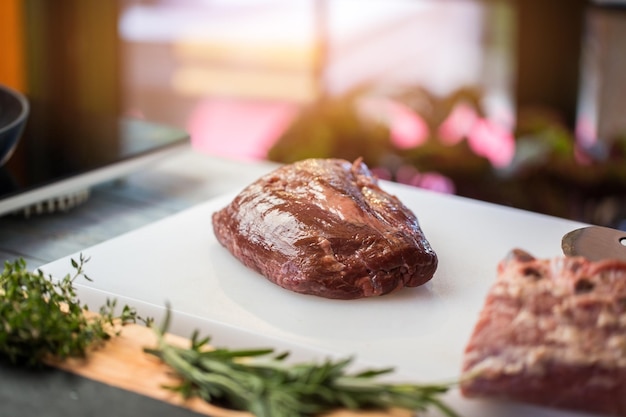 Morceau de viande crue. Herbes de couleur verte. Filet moelleux pour un steak. Principale source de protéines.