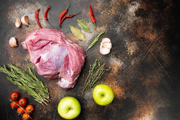 Morceau de viande crue de porc avec des assaisonnements sur la vieille vue de dessus de fond de table rustique sombre mise à plat avec espace de copie pour le texte