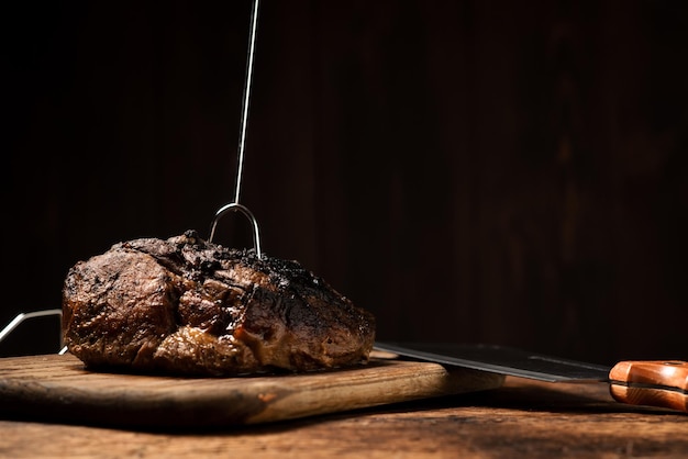 Un morceau de viande entier cuit au four Un morceau de porc aux épices cuit au four sur une planche de bois