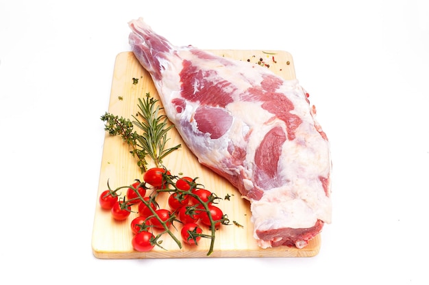 Un morceau de viande est sur une planche à découper avec un brin d'herbes dessus.