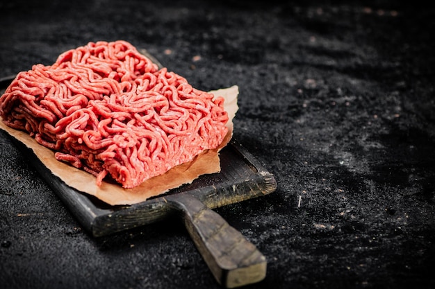 Photo un morceau de viande hachée crue sur une planche à découper