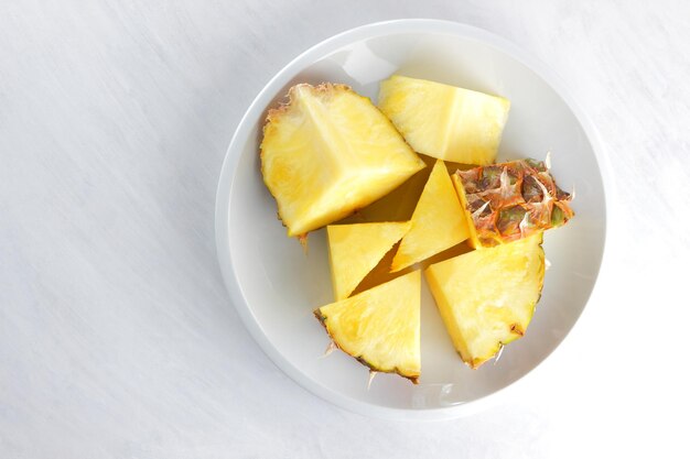 Morceaux d'ananas sur plaque blanche Ananas sur fond blanc Nourriture végétarienne Espace copie