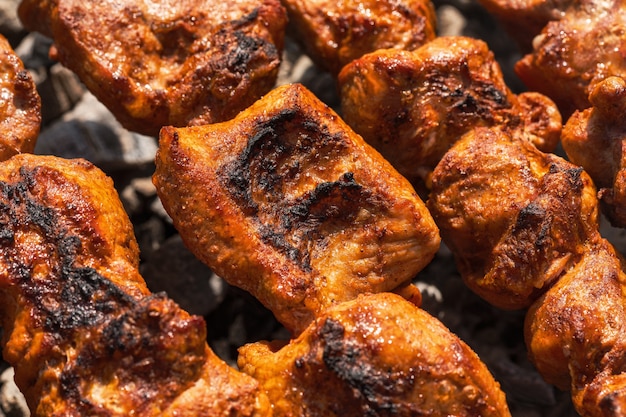 Morceaux de barbecue de porc ou de cuisson au barbecue sur un gril au charbon de bois à l'extérieur vue rapprochée des morceaux de cuisson