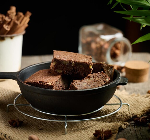 Morceaux de brownie cuits au four dans une poêle à frire noire en métal sur la table