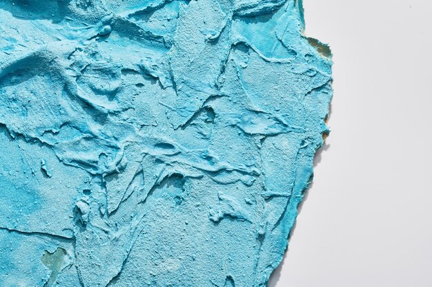 Morceaux de carton bleu en lambeaux de fond abstrait peinture chaotique tirets et traits sur le plâtre appliqué avec du mastic à la spatule texturexA